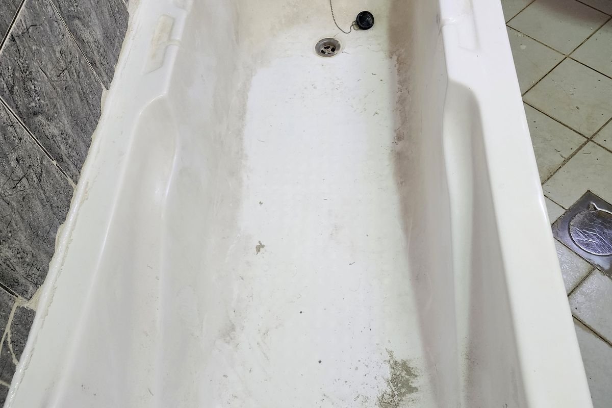Bathtub with limescale and staining before descaling