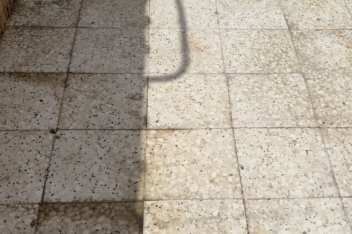 Villa patio paving greyed with dust and staining before pressure washing